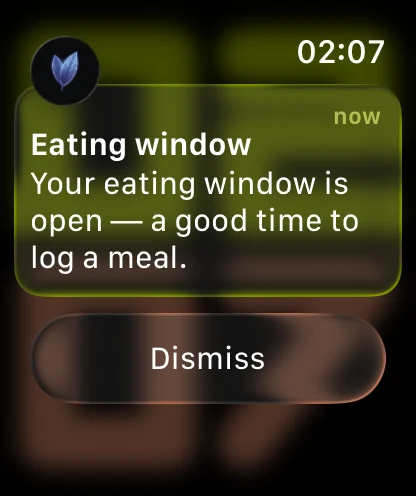 An Apple Watch showing a Vyra notification, headed by the periwinkle Vyra leaf mark: Eating window, and the message “Your eating window is open — a good time to log a meal.”